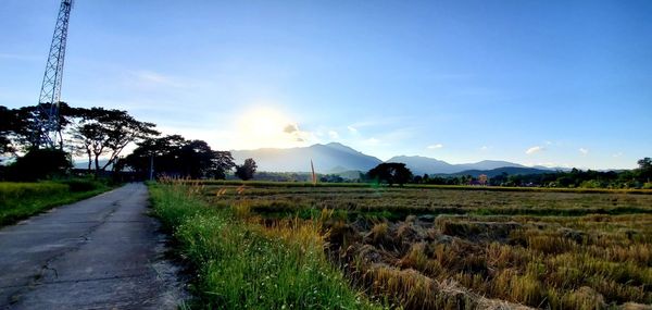 Road leading towards mountains against sky