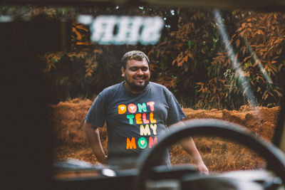 Pov from inside the car to the smiling happy man walking toward