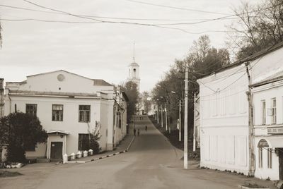 Empty road amidst buildings against sky