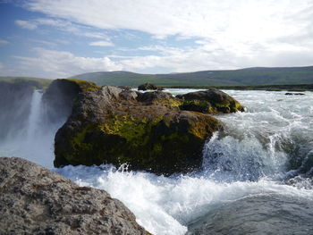 Scenic view of waterfall against sky