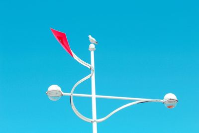 Low angle view of street light against blue sky