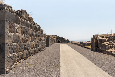 Road by wall against clear sky