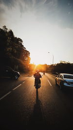 Man on road against sky during sunset