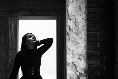 Young woman standing against wall