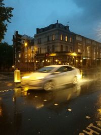 Cars on illuminated road against sky in city at night