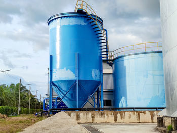 Metallic structure in factory against sky