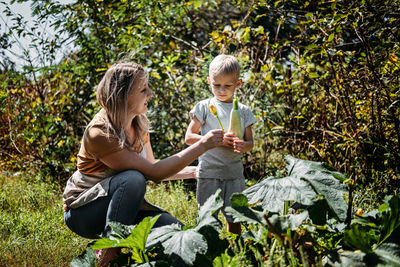 Green thumbs, spring is here, home gardens and picking vegetables. happy family, mom and kid