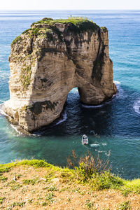 Rock formation in sea against sky