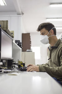 Man working on table with mask