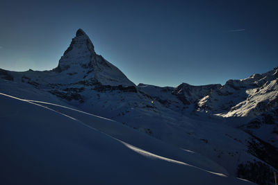 Scenic view of snowcapped mountains against clear sky