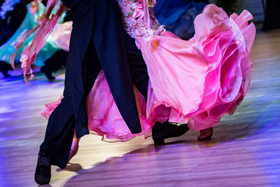 Low section of couple dancing on hardwood floor