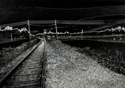 Railroad tracks on field at night