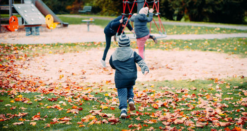 Rear view of man walking on field during autumn