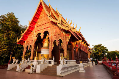 Statue of temple against building and sky