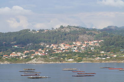 Scenic view of sea by buildings against sky