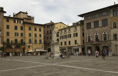 People on street against buildings in city