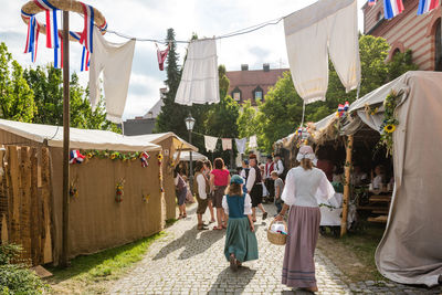 Clothesline over people in traditional clothing walking in footpath