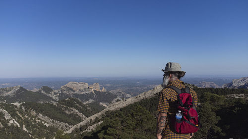 Man standing on the cliff.  hiker climbed to the rocky summit and enjoyed the views of the valley.