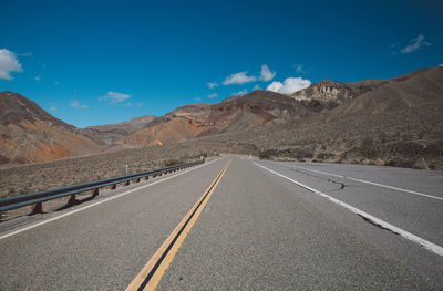 Road by mountain against sky