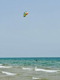 People in sea against clear sky