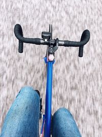 Low section of woman riding bicycle on road