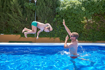 Man playing with a child in a pool