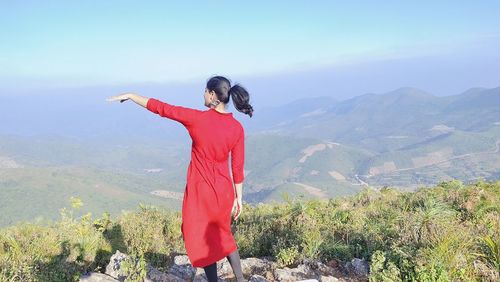 Woman standing on mountain against sky