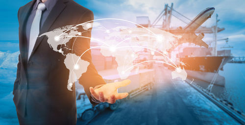 Digital composite image of businessman with world map at dock