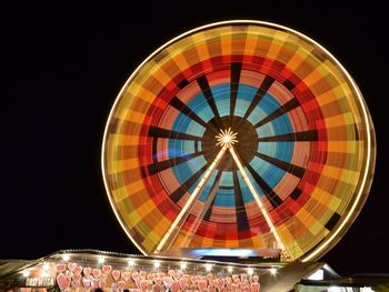 Low angle view of illuminated ferris wheel against sky at night