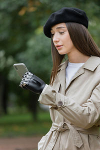 Young woman using phone while standing outdoors