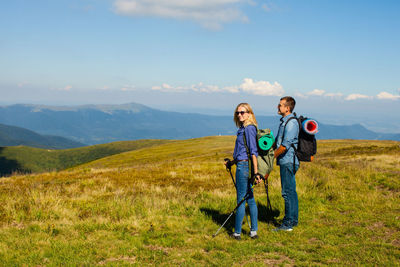 Full length of friends on mountain against sky