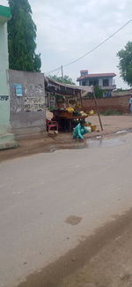 Vehicles on road against sky in city