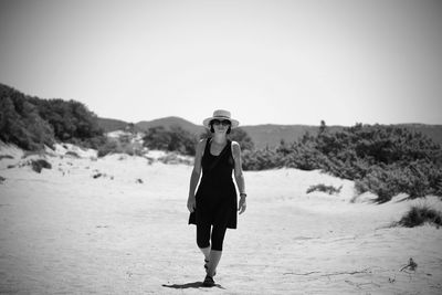 Full length portrait of woman standing on land