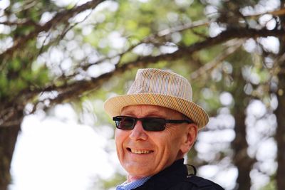 Portrait of smiling senior man wearing sunglasses and hat