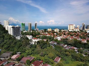 Scenic view of cityscape by sea against sky