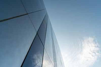 Low angle view of modern glass building against sky