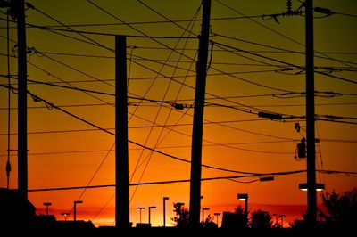 Silhouette electricity pylon against sky during sunset