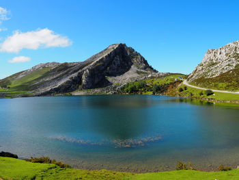 Scenic view of lake and mountains against blue sky