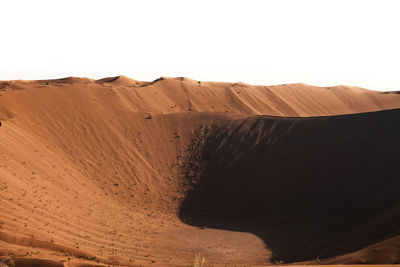 Sand dune in desert against clear sky