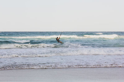 Man surfing in sea against clear sky