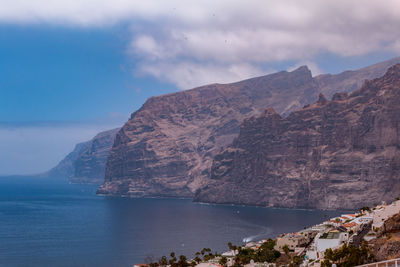 Scenic view of sea and mountains against sky