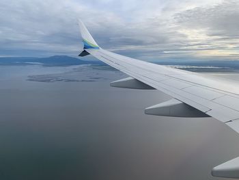 Cropped image of airplane wing against sky