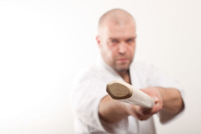 Portrait of man holding camera over white background