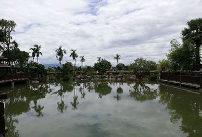 Scenic view of lake by trees against sky