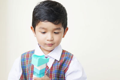 Portrait of boy standing against white background