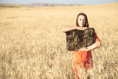 Portrait of young woman standing on field