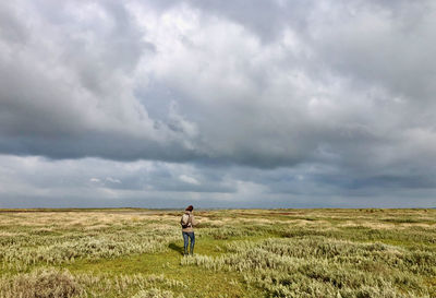 Man standing on field against sky