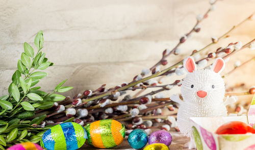 Close-up of easter bunny and eggs on table against wall