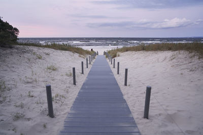 Wooden pier on sea against sky