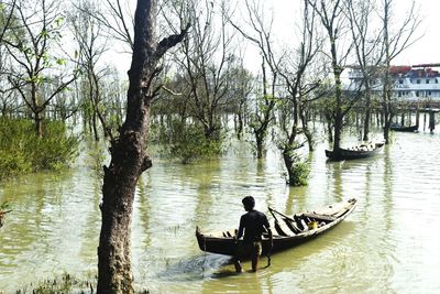 Man sitting on boat in river